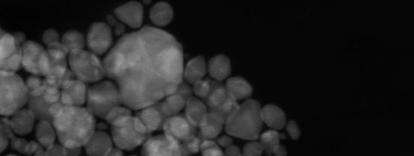 Thesis cover featuring a greyscale electron microscopy image of mixed-metal nanoparticles with the title “Electrocatalytic Performance and in situ Guided Synthesis of Solid Solutions” and the author name Andreas Dueholm Bertelsen.